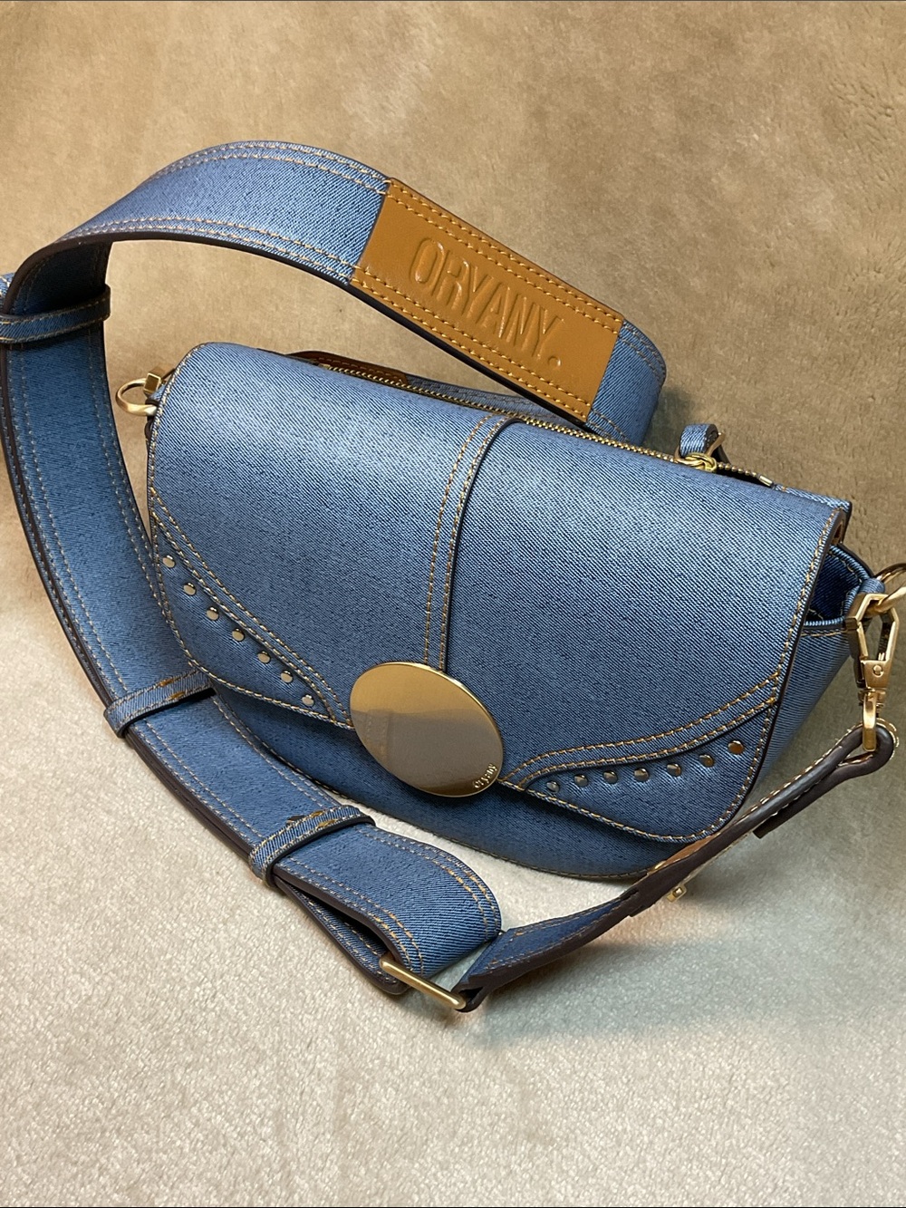 Oryany Lottie Blue Denim-Effect Crossbody with Gold Hardware and Tan Strap Patch